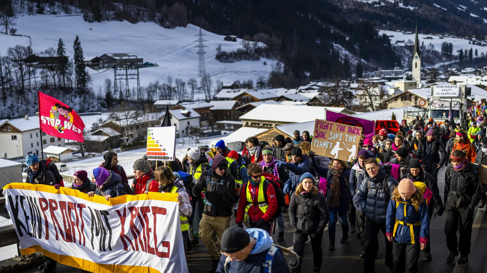 
                    Centenas de manifestantes marcham em direção a Davos
                