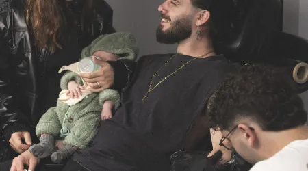 Syro faz tatuagem...com o filho bebé ao colo