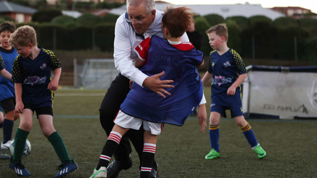 Primeiro-ministro australiano cai sobre menino durante jogo de futebol 