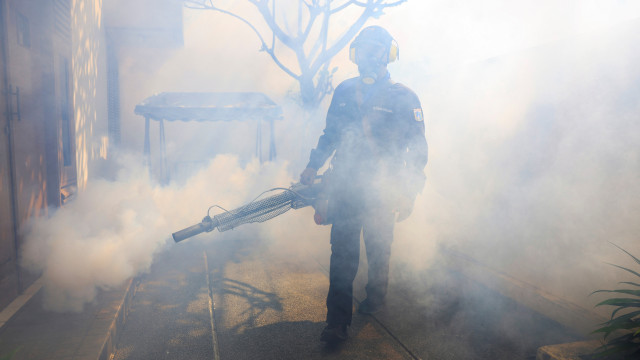 Trabalhadores fazem fumigações nas ruas de Jacarta para combater dengue