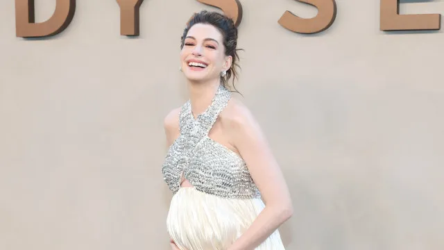 
                    Anne Hathaway realça gravidez em vestido com cristais
                