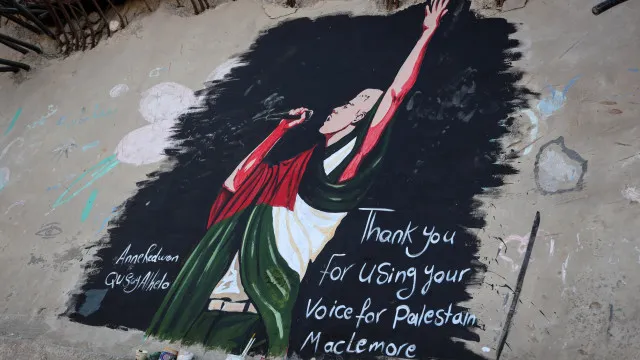 
                    Artistas pintam mural de homenagem a Macklemore em Gaza. As imagens
                