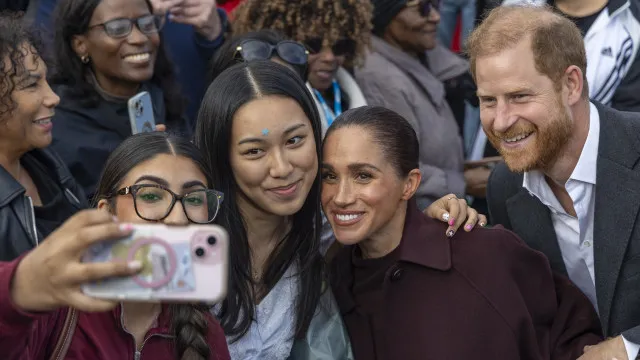 
                    Selfies, abraços e presentes: Harry e Meghan no 1.º evento no Reino Unido
                