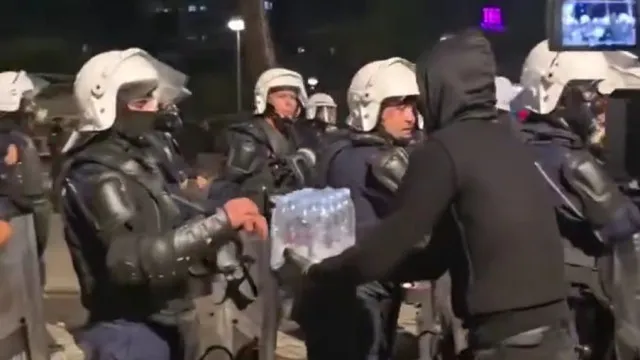 
                    No caos, a preocupação: O gesto de um manifestante com polícia na Albânia
                