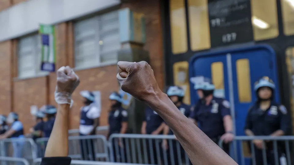 Manifestantes e membros da polícia ajoelham-se durante protestos