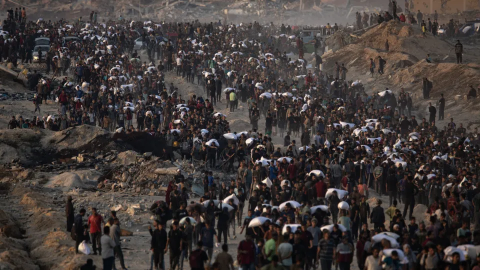 Displaced Palestinians carry bags of flour along Rashid Street in western Gaza City.