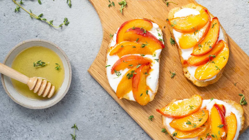 Tostas de pêssego e mel para uma lanche doce, mas saudável