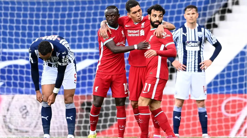 Liverpool's Egyptian midfielder Mohamed Salah (2R) celebrates scoring his team's first goal with Liverpool's Brazilian midfielder Roberto Firmino(C) and Liverpool's Senegalese striker Sadio Mane (2L) during the English Premier League football match betwee