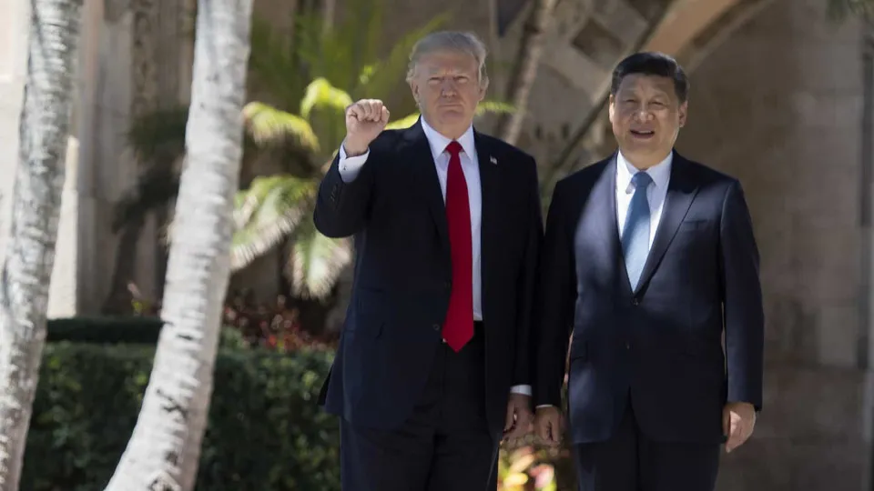 TOPSHOT - US President Donald Trump (L) pumps his fist as he and Chinese President Xi Jinping (R) walk together at the Mar-a-Lago estate in West Palm Beach, Florida, April 7, 2017. / AFP PHOTO / JIM WATSON        (Photo credit should read JIM WATSON/AFP v