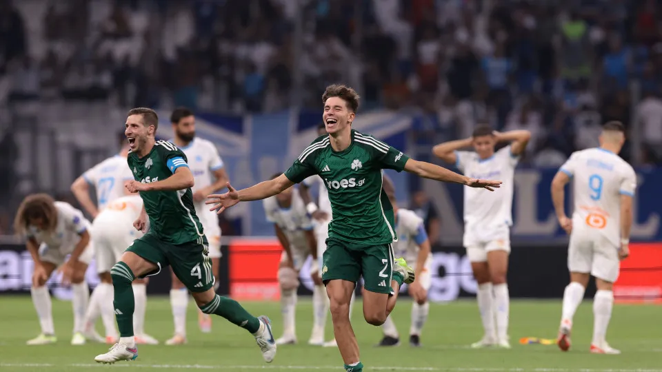 MARSEILLE, FRANCE - AUGUST 15: Olympique de Marseille players react as Ruben Perez and Georgios Vagiannidis of Panathinaikos FC celebrate team mate Filip Mladenovic's decisive penalty in the shoot out following the UEFA Champions League Third Qualifying R