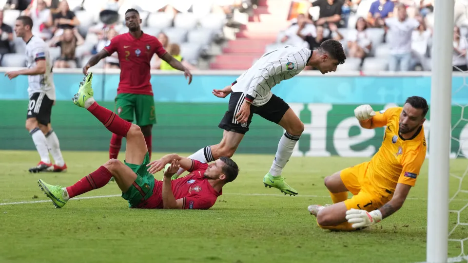 Portugal's defender Ruben Dias (L floor) reacts after scoring an own goal for Germany's first goal during the UEFA EURO 2020 Group F football match between Portugal and Germany at Allianz Arena in Munich on June 19, 2021. (Photo by Matthias Schrader / POO
