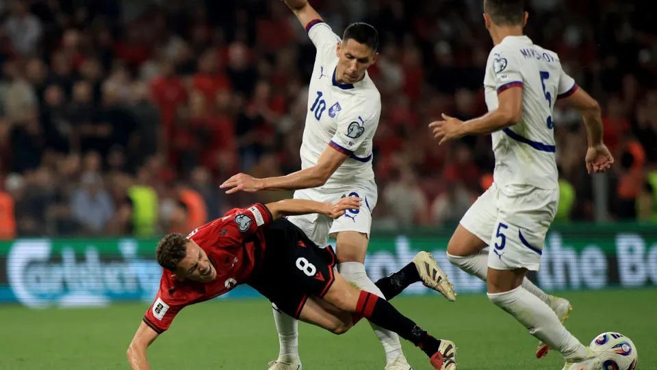 Albania's midfielder #08 Kristjan Asllani (L) and Serbia's midfielder #10 Sasa Lukic (C) fight for the ball during the 2026 World Cup qualifiers Europe zone, 1st round group K football match between Albania and Serbia at the Air Albania Stadium in Tirana 