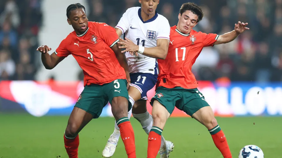 WEST BROMWICH, ENGLAND - MARCH 24: Omari Hutchinson of England battles for the ball with Flavio Nazinho and Diogo Nascimento of Portugal  during the Men's U21 international match between England and Portugal at The Hawthorns on March 24, 2025 in West Brom