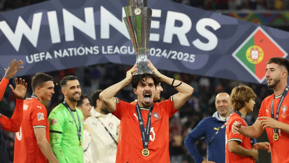 MUNICH,  - JUNE 08: Vitinha of Portugal rests the UEFA Nations League Trophy on his head following victory in the UEFA Nations League 2025 final match between Portugal and Spain at Munich Football Arena on June 08, 2025 in Munich, . (Photo b