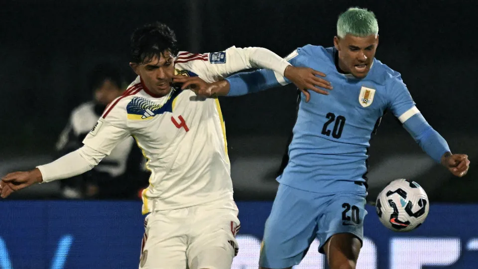 Uruguay's midfielder #20 Maximiliano Araujo and Venezuela's defender #04 Jon Aramburu fight for the ball during the 2026 FIFA World Cup South American qualifiers football match between Uruguay and Venezuela at the Centenario stadium in Montevideo on June 