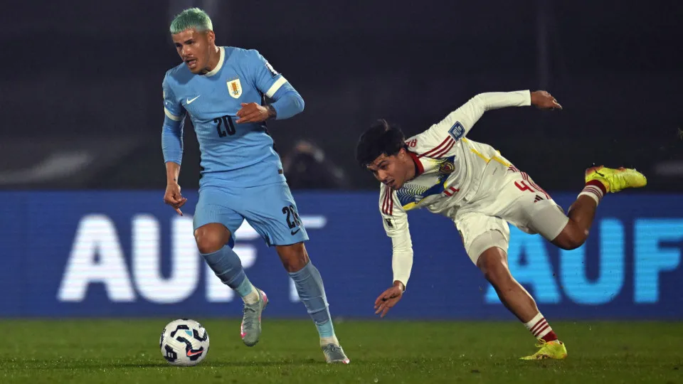 Uruguay's midfielder #20 Maximiliano Araujo and Venezuela's defender #04 Jon Aramburu fight for the ball during the 2026 FIFA World Cup South American qualifiers football match between Uruguay and Venezuela at the Centenario stadium in Montevideo on June 