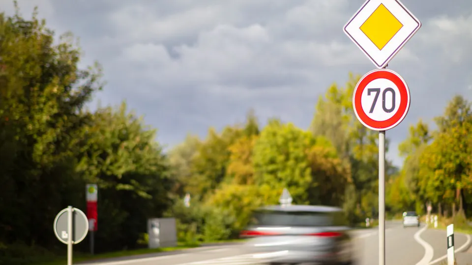 Carro rápido após sinal de limite de velocidade.