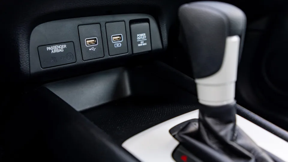 Tomadas USB num carro, à frente da alavanca de mudanças.