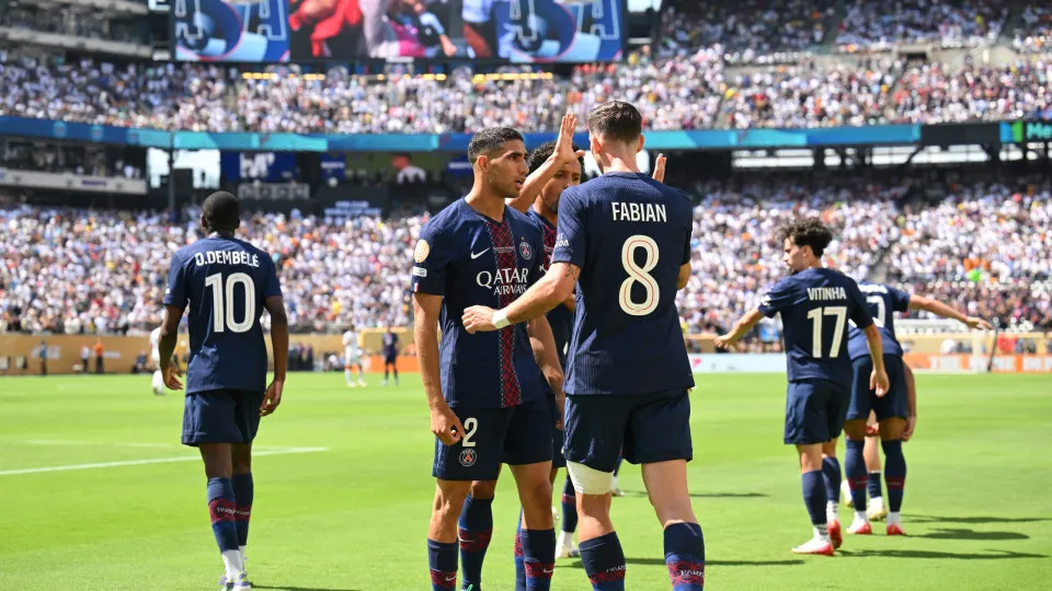 Paris Saint-Germain's Spanish midfielder #08 Fabian Ruiz (R) celebrates scoring his team's first goal with Moroccan defender #02 Achraf Hakimi during the FIFA Club World Cup 2025 semifinal football match between France's Paris Saint-Germain and Spain's Re
