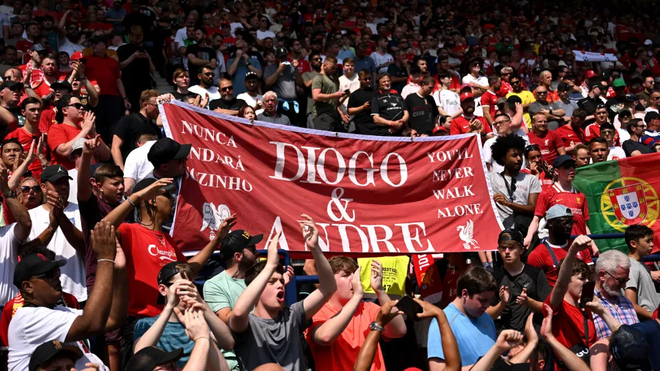 PRESTON, ENGLAND - JULY 13: (THE SUN OUT, THE SUN ON SUNDAY OUT) A young fan of Liverpool holds up a banner which pays tribute to former Liverpool player Diogo Jota and his brother Andre Silva who both passed away on the 3rd of July 2025 prior to the pre-