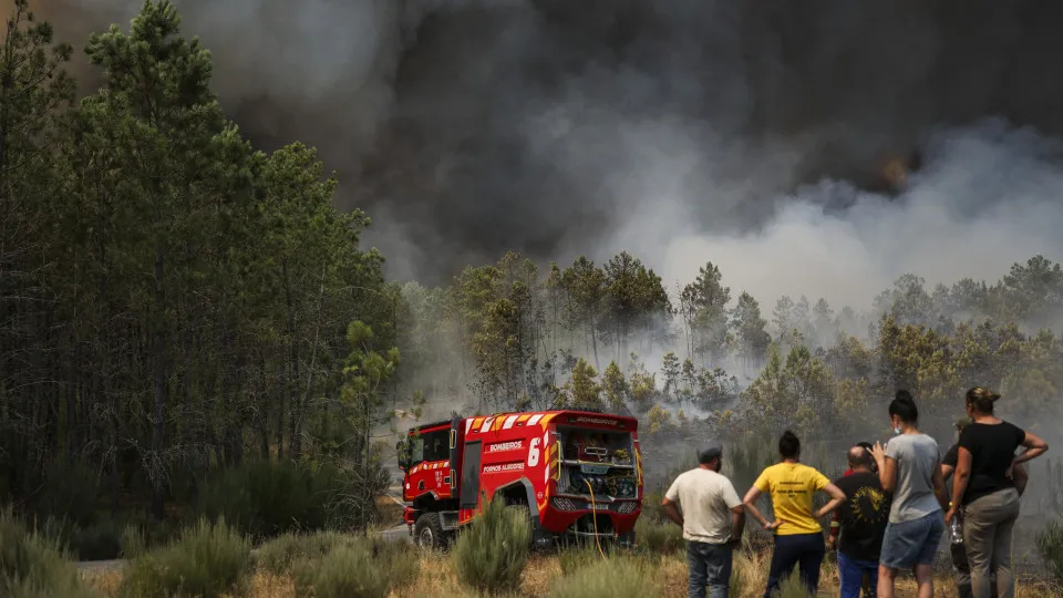 People watch the progression of a wildfire at Casal do Monte village in Trancoso, Portugal on August 13, 2025. (Photo by PATRICIA DE MELO MOREIRA / AFP) (Photo by PATRICIA DE MELO MOREIRA/AFP via Getty Images)          