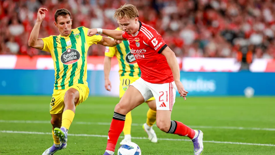 LISBON, PORTUGAL - AUGUST 23: Andreas Schjelderup of SL Benfica (R) controls the ball under pressure from Tiago Miguel Silva Manso of CD Tondela (L) during the Primeira Liga match between SL Benfica and CD Tondela at Estadio da Luz on August 23, 2025 in L